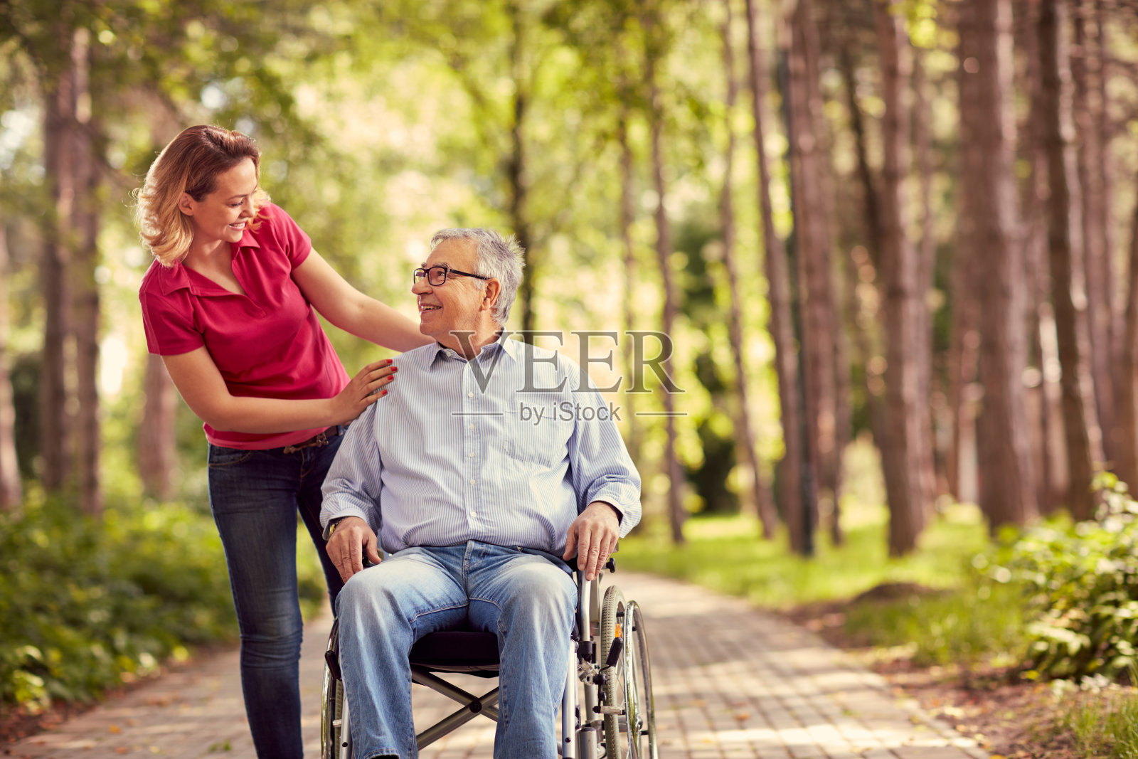 微笑的女人和坐在轮椅上残疾的父亲照片摄影图片