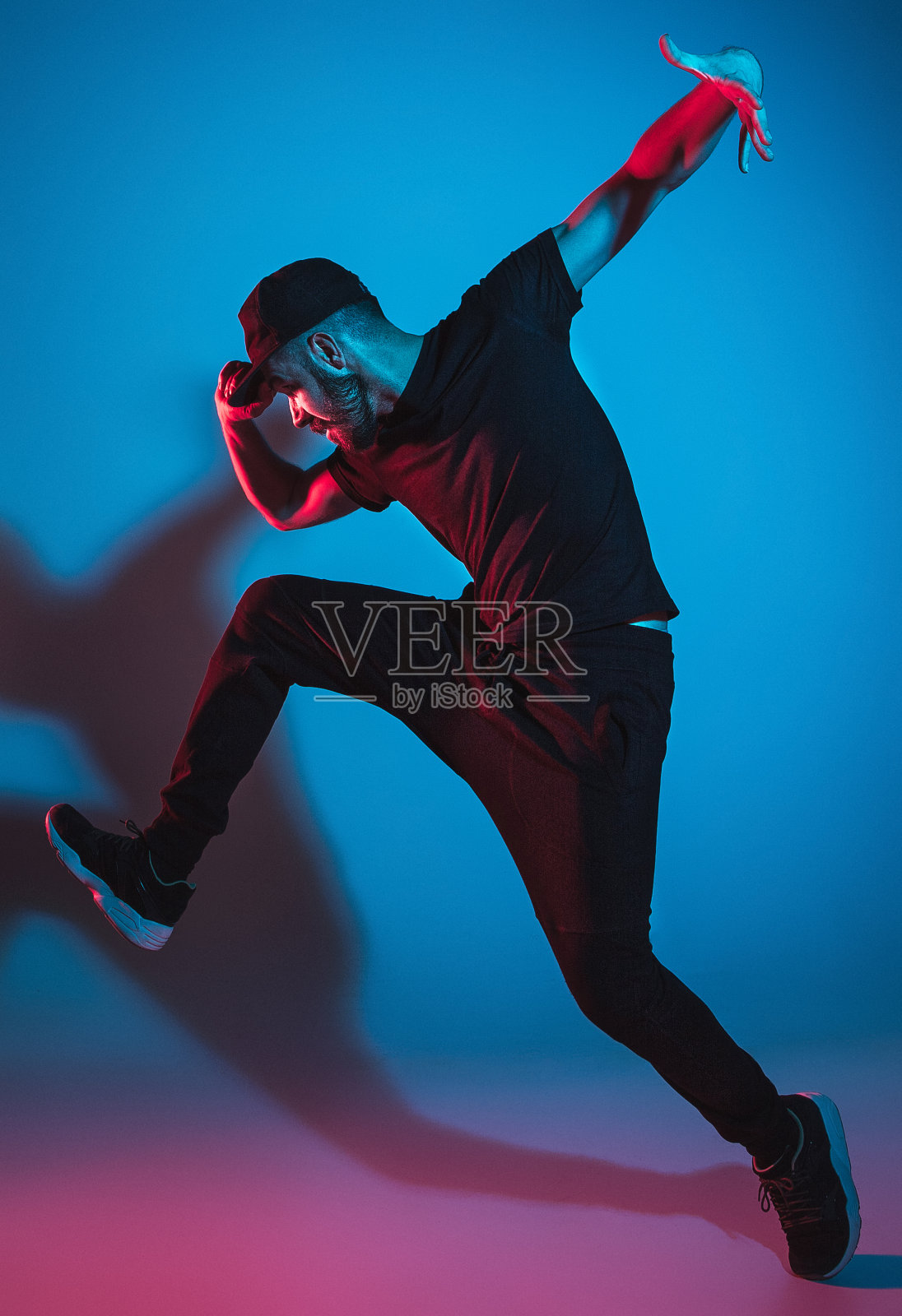 一个街舞男霹雳舞的剪影在多彩的背景上跳舞照片摄影图片