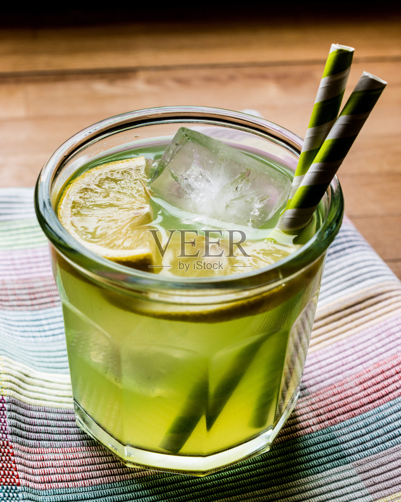 绿桃酸鸡尾酒加冰和柠檬。照片摄影图片