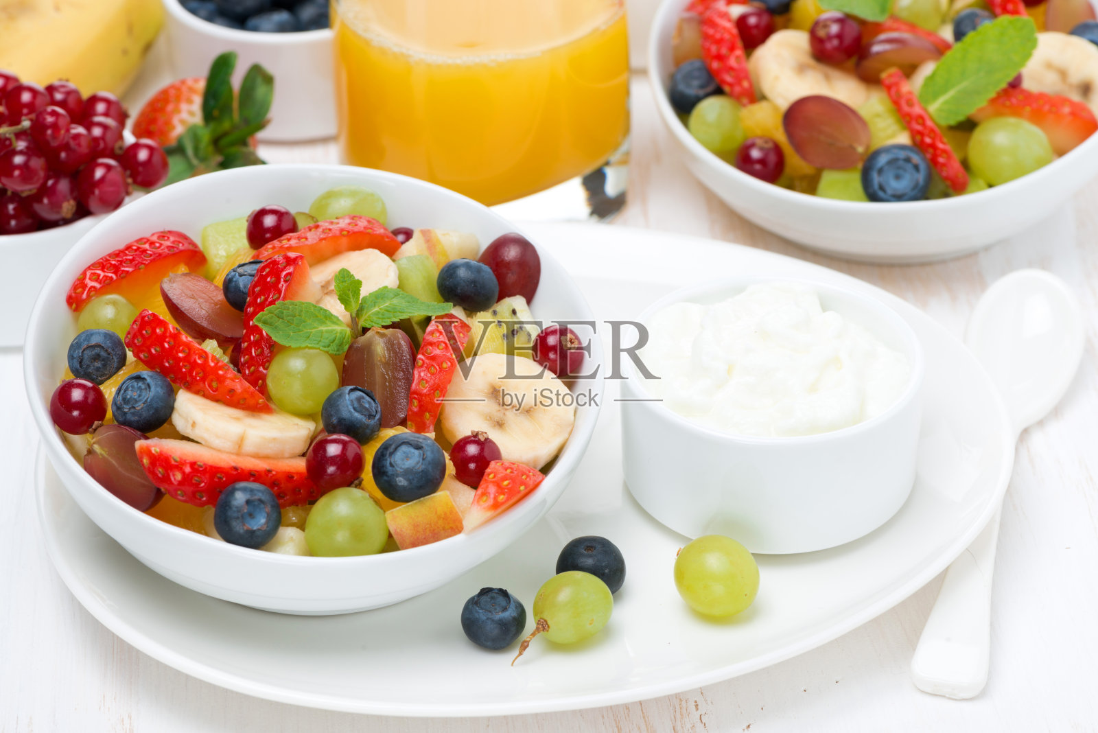 早餐有新鲜水果、浆果沙拉和奶油照片摄影图片