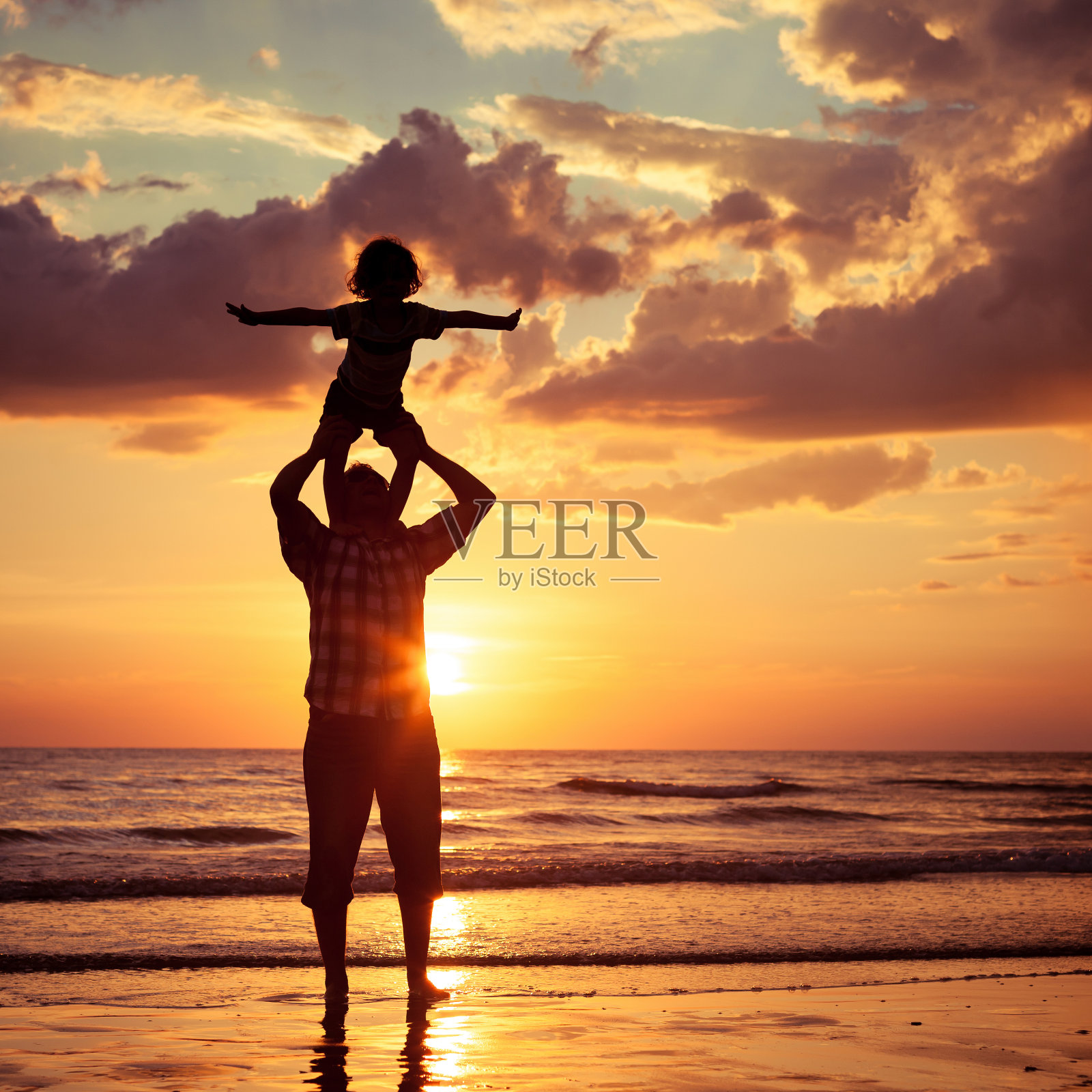 爸爸和儿子在海滩上玩照片摄影图片