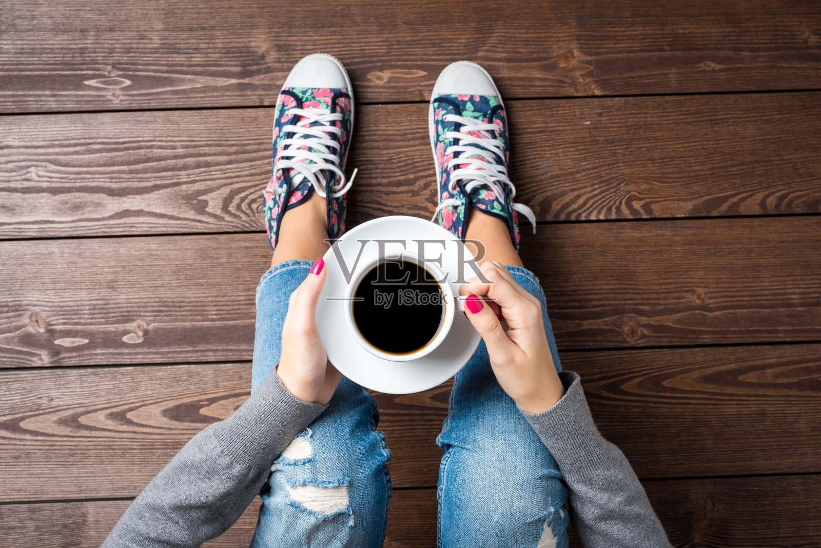 坐在木地板上喝咖啡的女人照片摄影图片