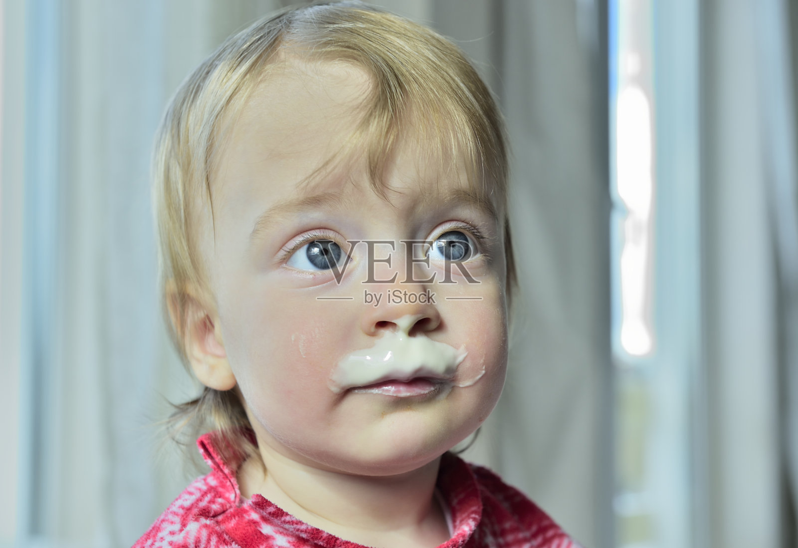 一个长着牛奶胡子的小女孩的肖像。照片摄影图片