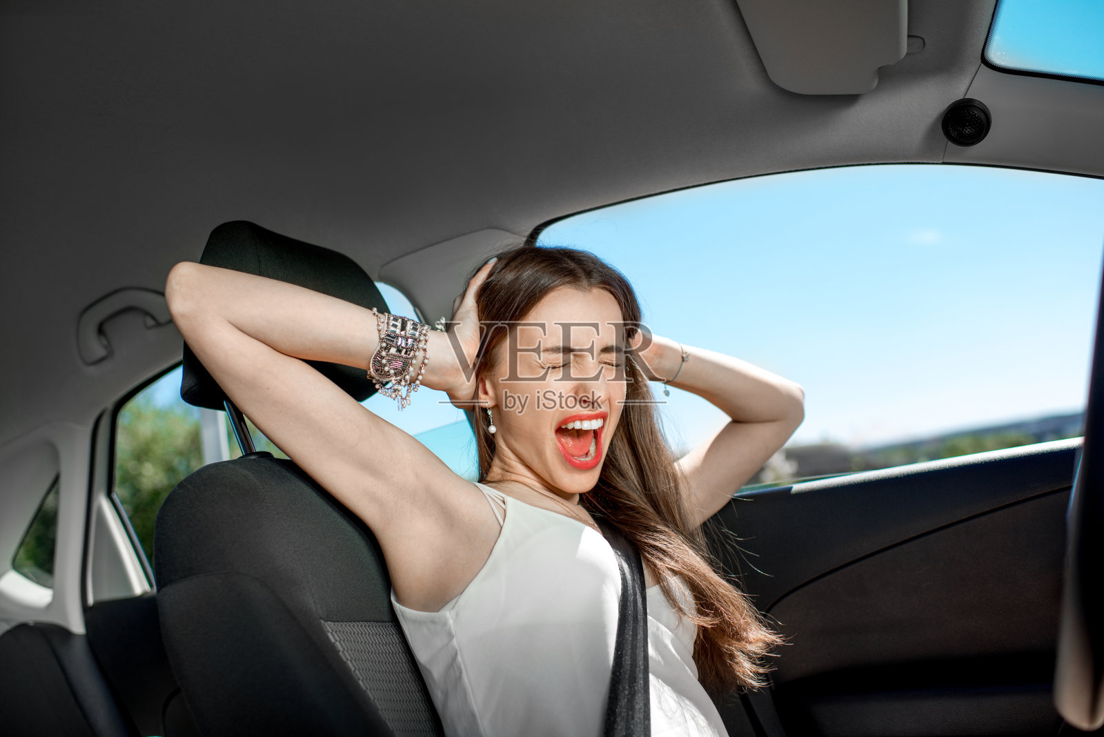 年轻悲伤的女人对着车大喊照片摄影图片