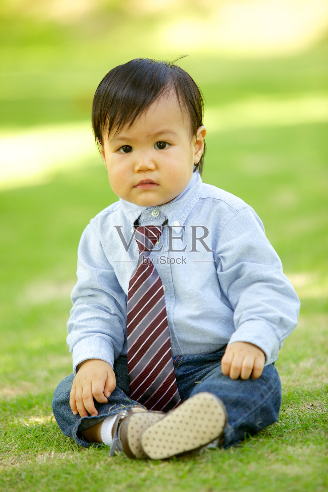 坐在草地上的男婴照片摄影图片