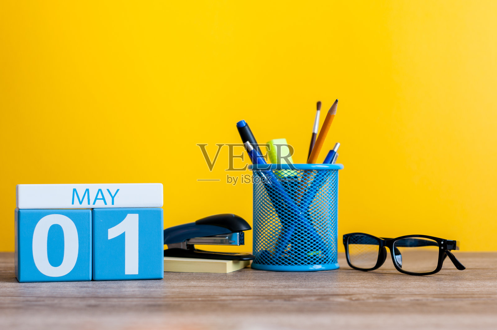 5月1日。月1日，日历放在商务办公室桌上，工作场所以黄色为背景。春天的时间照片摄影图片