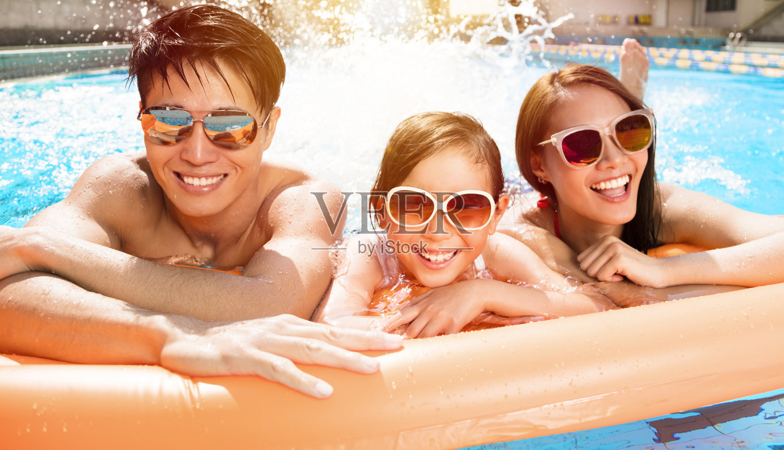 快乐的家庭在游泳池里玩耍照片摄影图片