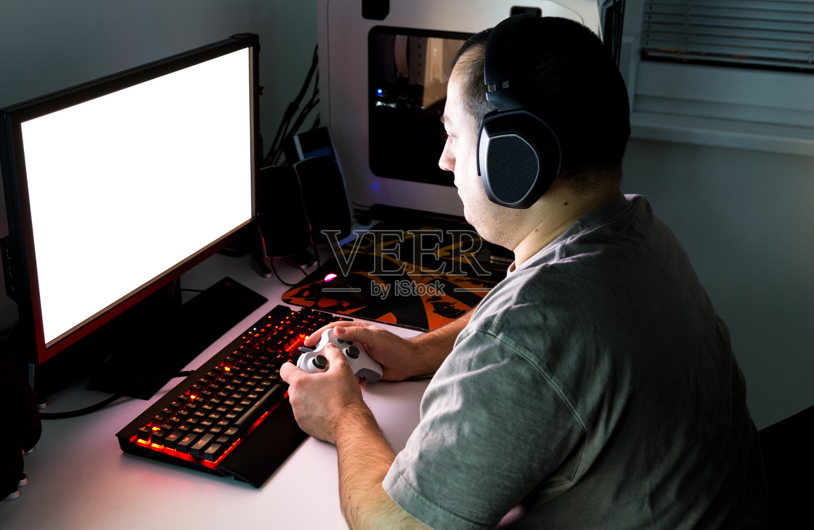 用手柄、键盘、鼠标在定制的桌面上玩电脑游戏。照片摄影图片