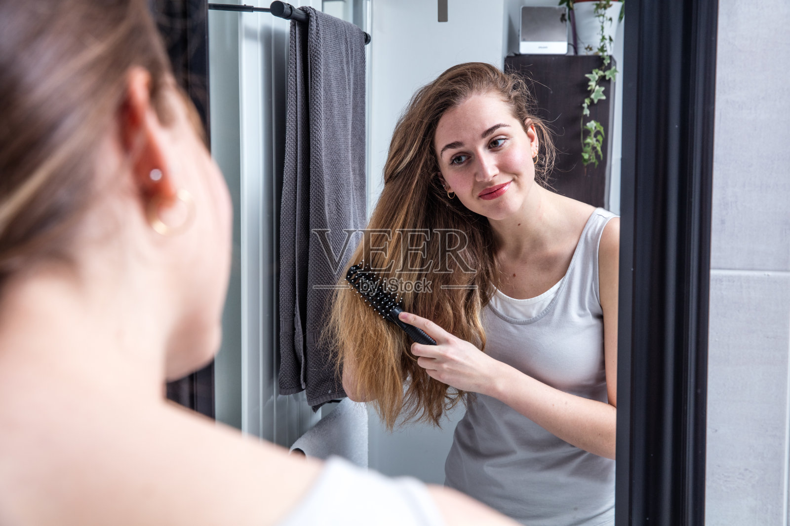 迷人的年轻女子在镜子前梳着长发照片摄影图片