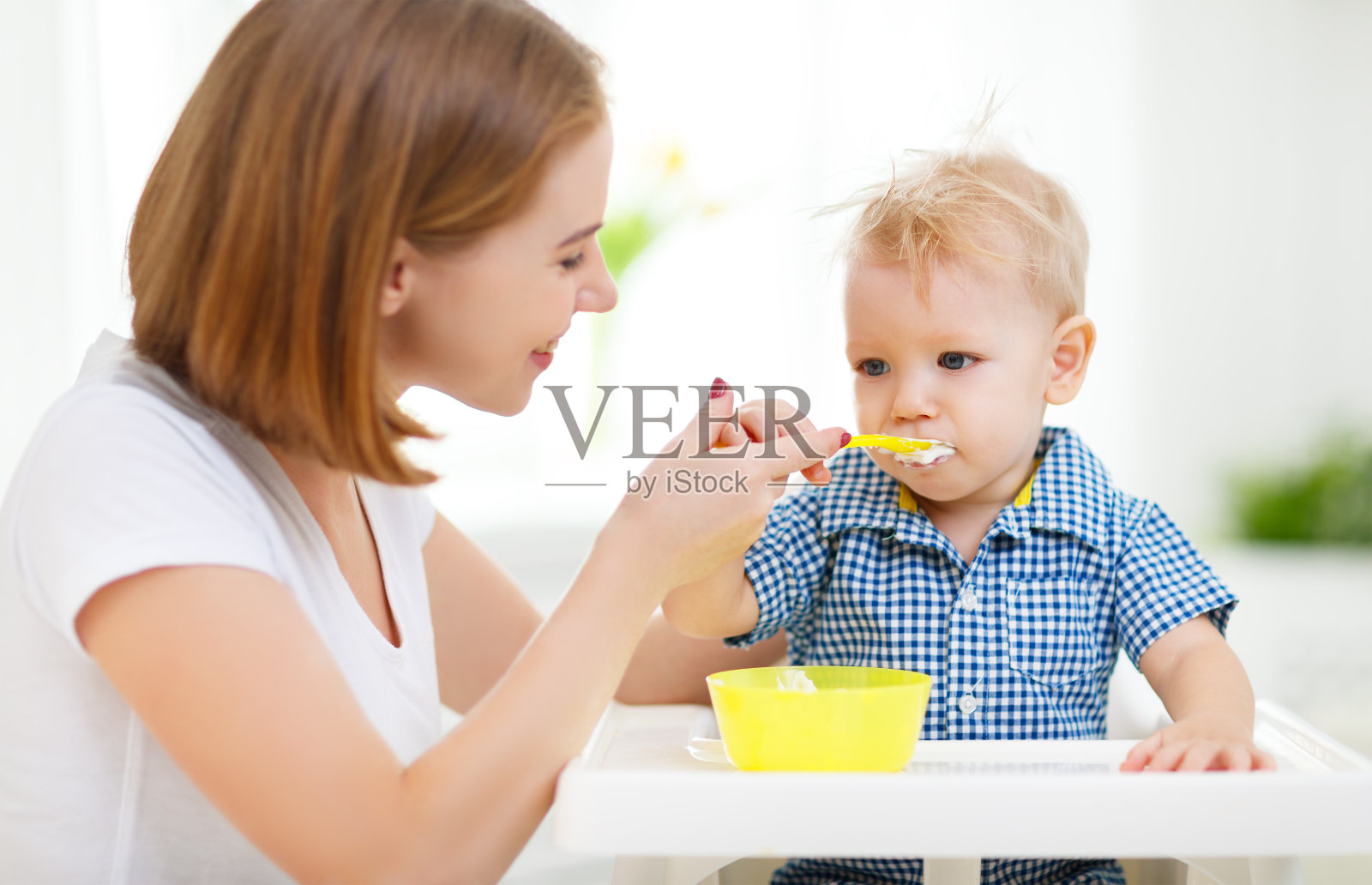 母亲用勺子喂婴儿照片摄影图片
