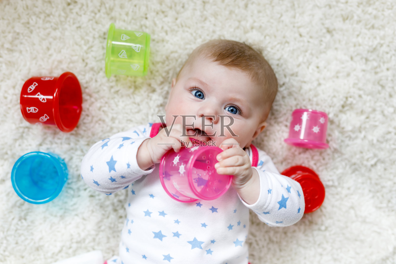 可爱可爱的新生婴儿玩彩色教育摇响器玩具照片摄影图片