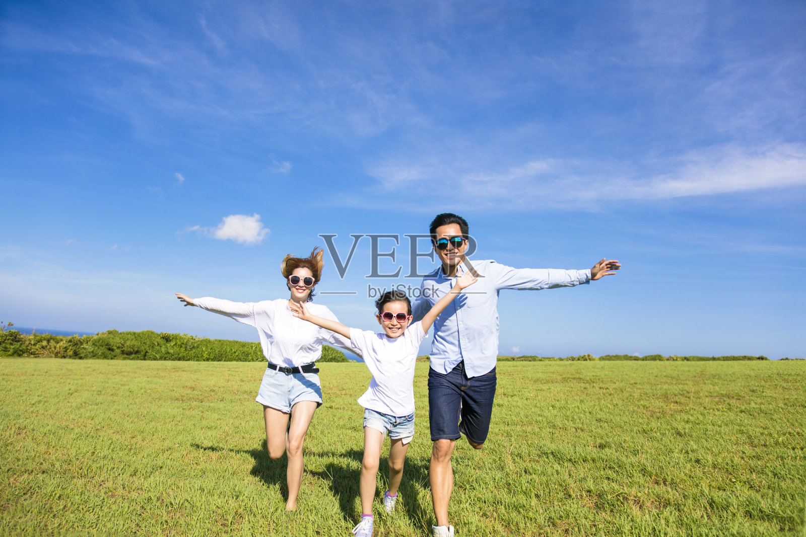幸福的家庭一起在草地上奔跑照片摄影图片