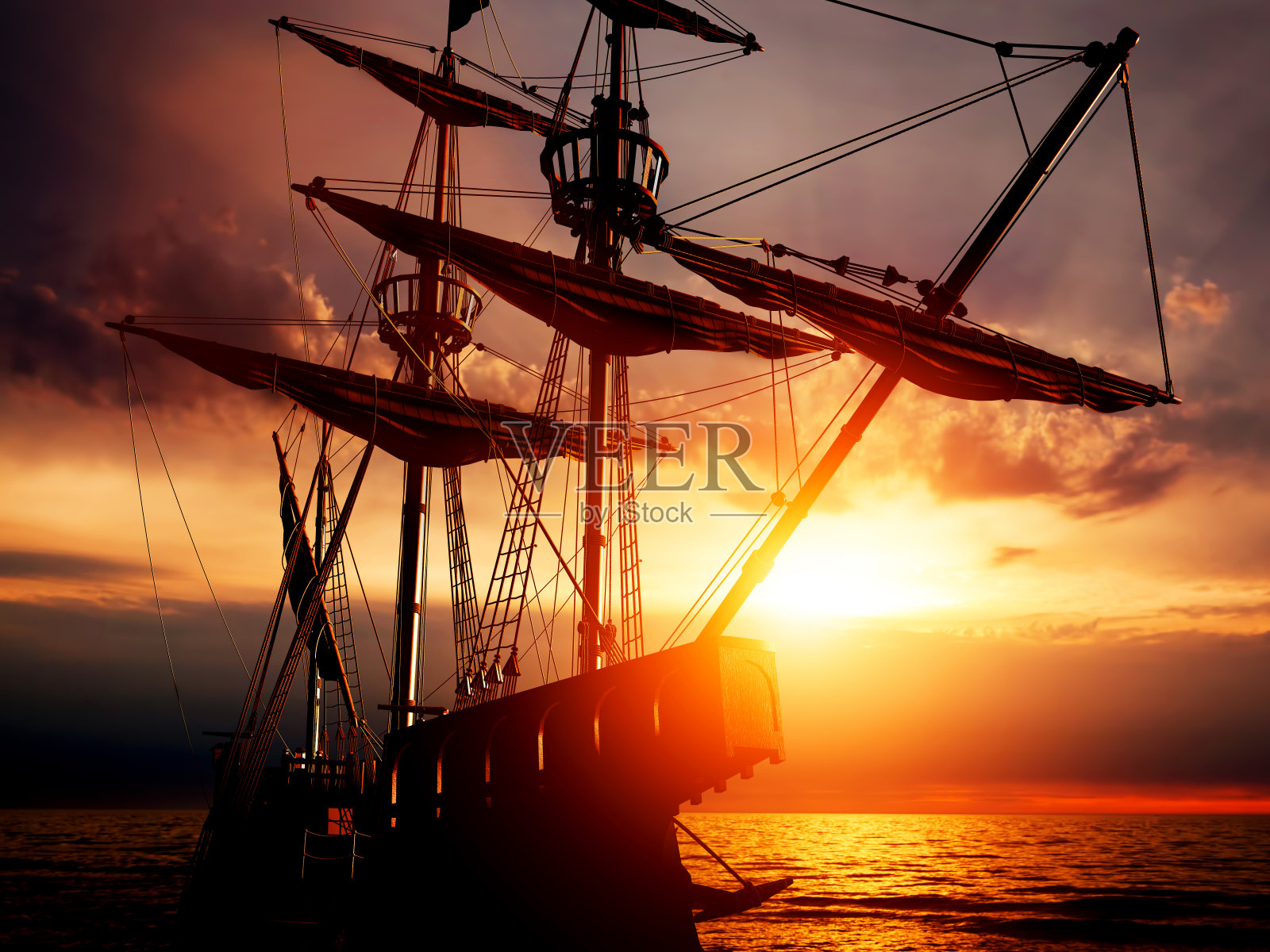 日落时分，平静的海面上一艘古老的海盗船。照片摄影图片