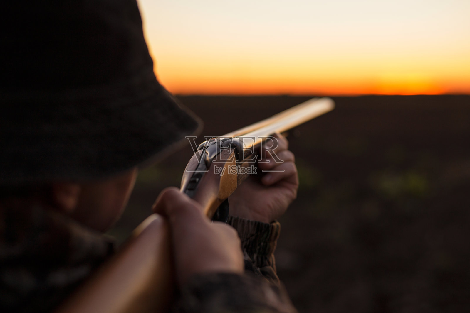 猎人在黄昏瞄准猎枪照片摄影图片