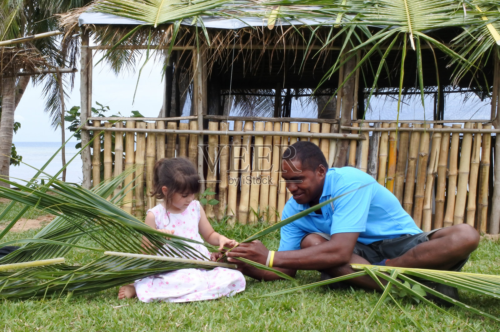 土著斐济男子教女孩如何制作篮子照片摄影图片