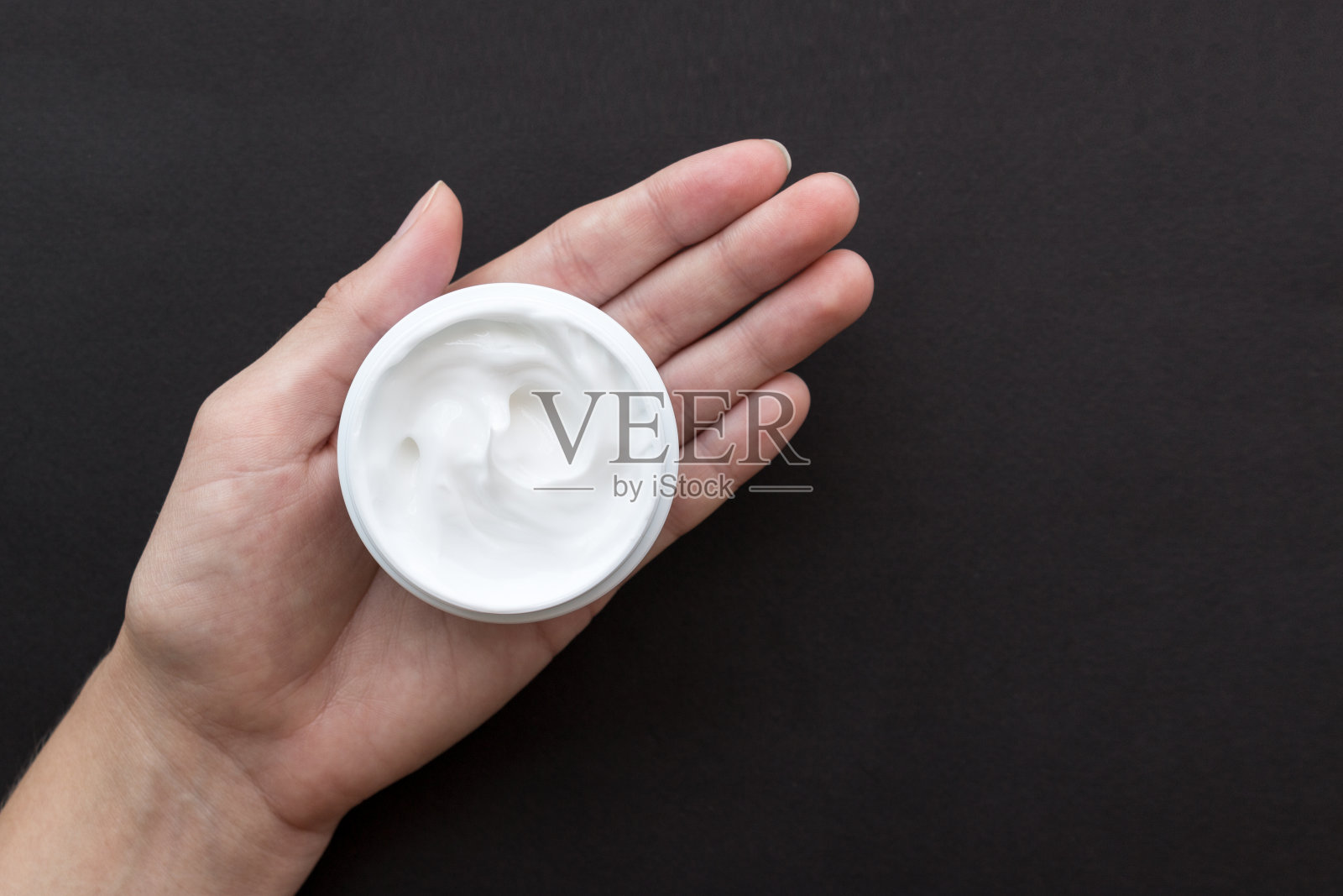 用于脸部或身体的乳霜，用白色容器盛于女性手上照片摄影图片
