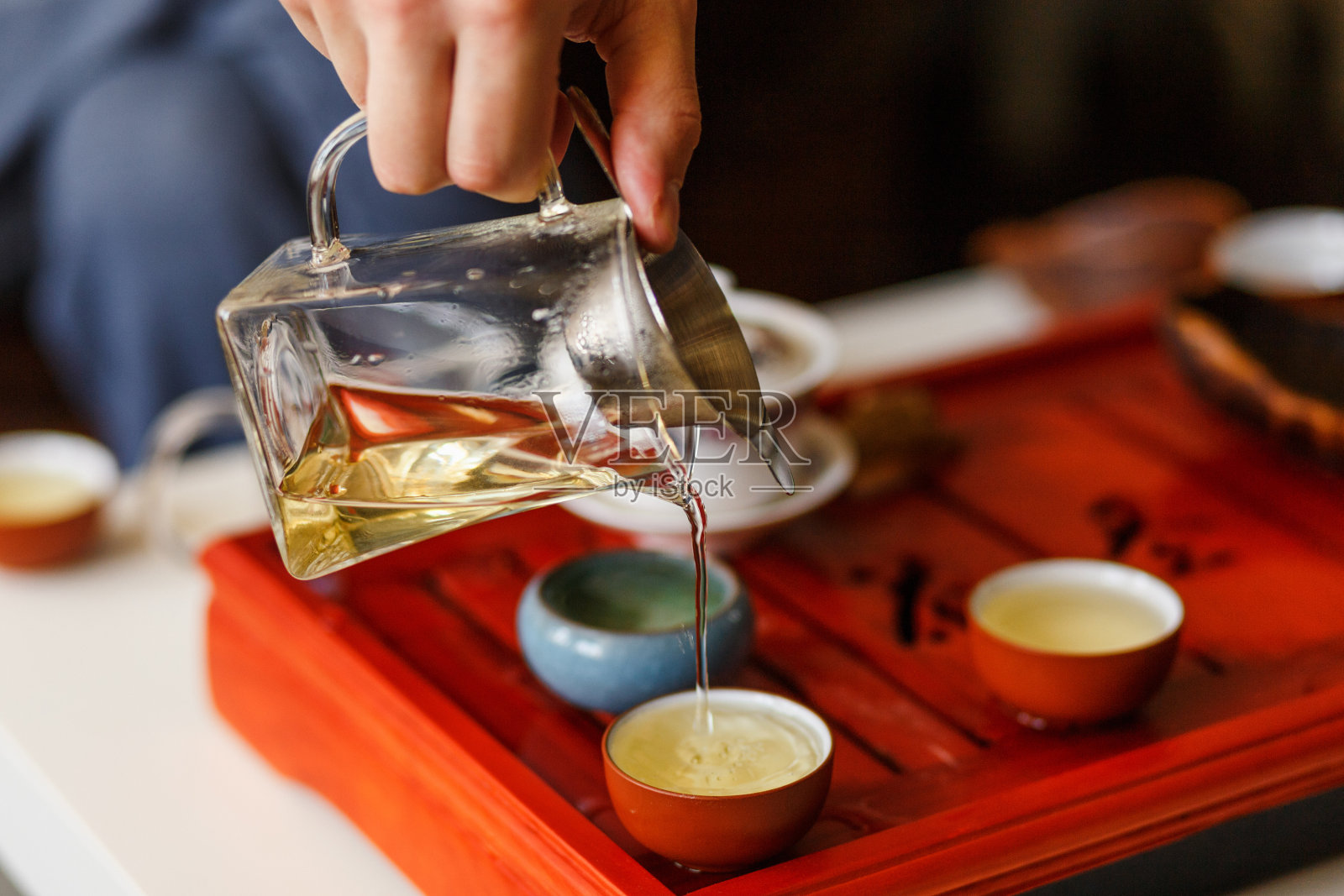茶道。男人的手倒着茶。照片摄影图片