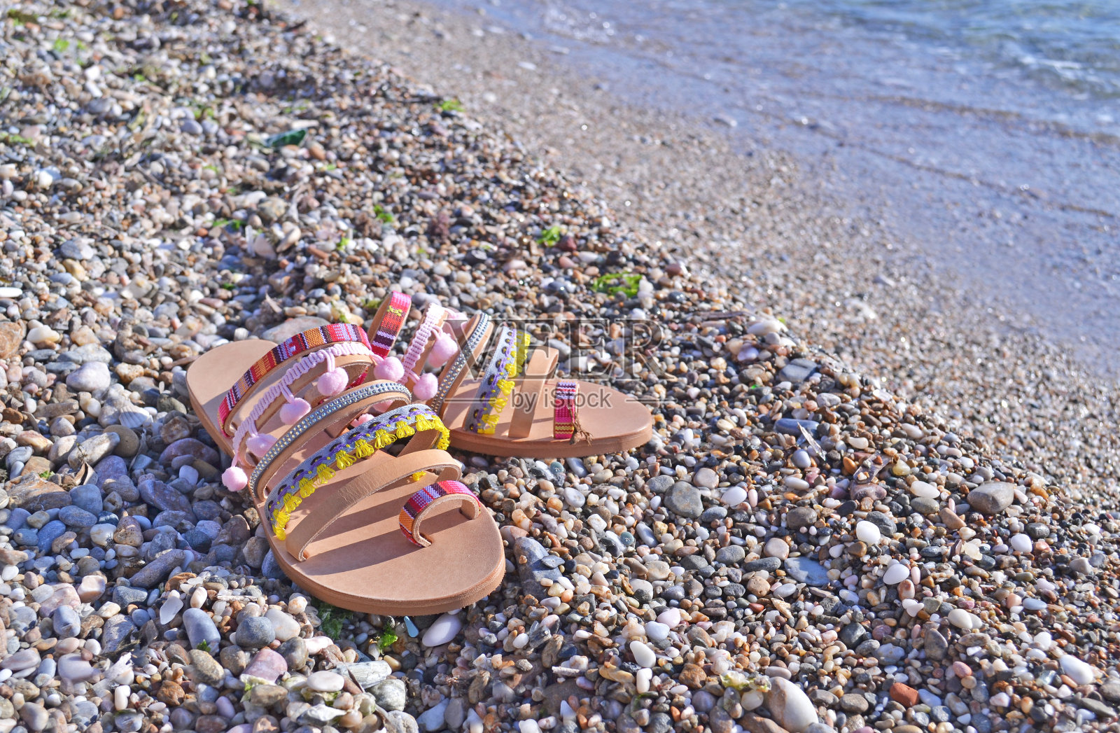 沙滩上的希腊皮革凉鞋照片摄影图片