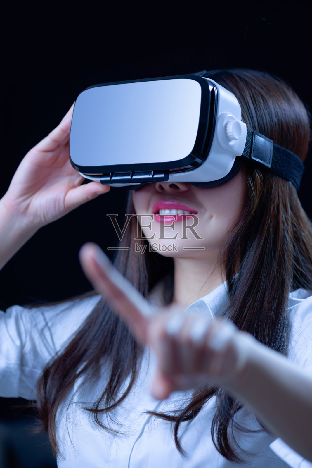 戴着虚拟现实智能眼镜的年轻女子。照片摄影图片