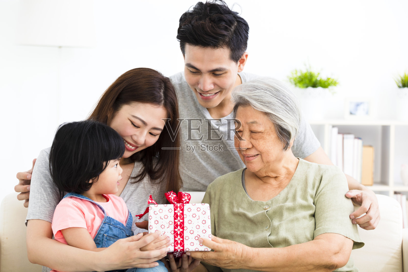 快乐的小女孩给她的奶奶礼物照片摄影图片