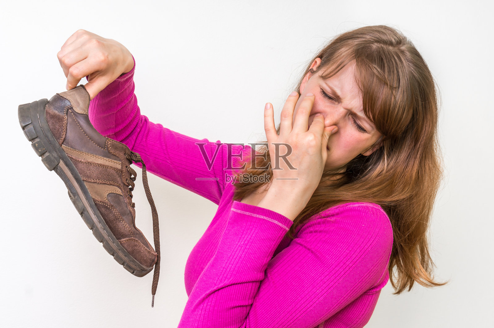 女人拿着脏臭的鞋子照片摄影图片
