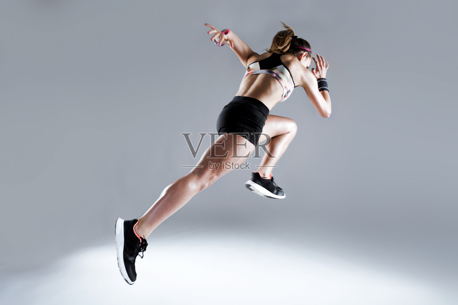 健康和运动的年轻女子跑在白色的背景。照片摄影图片