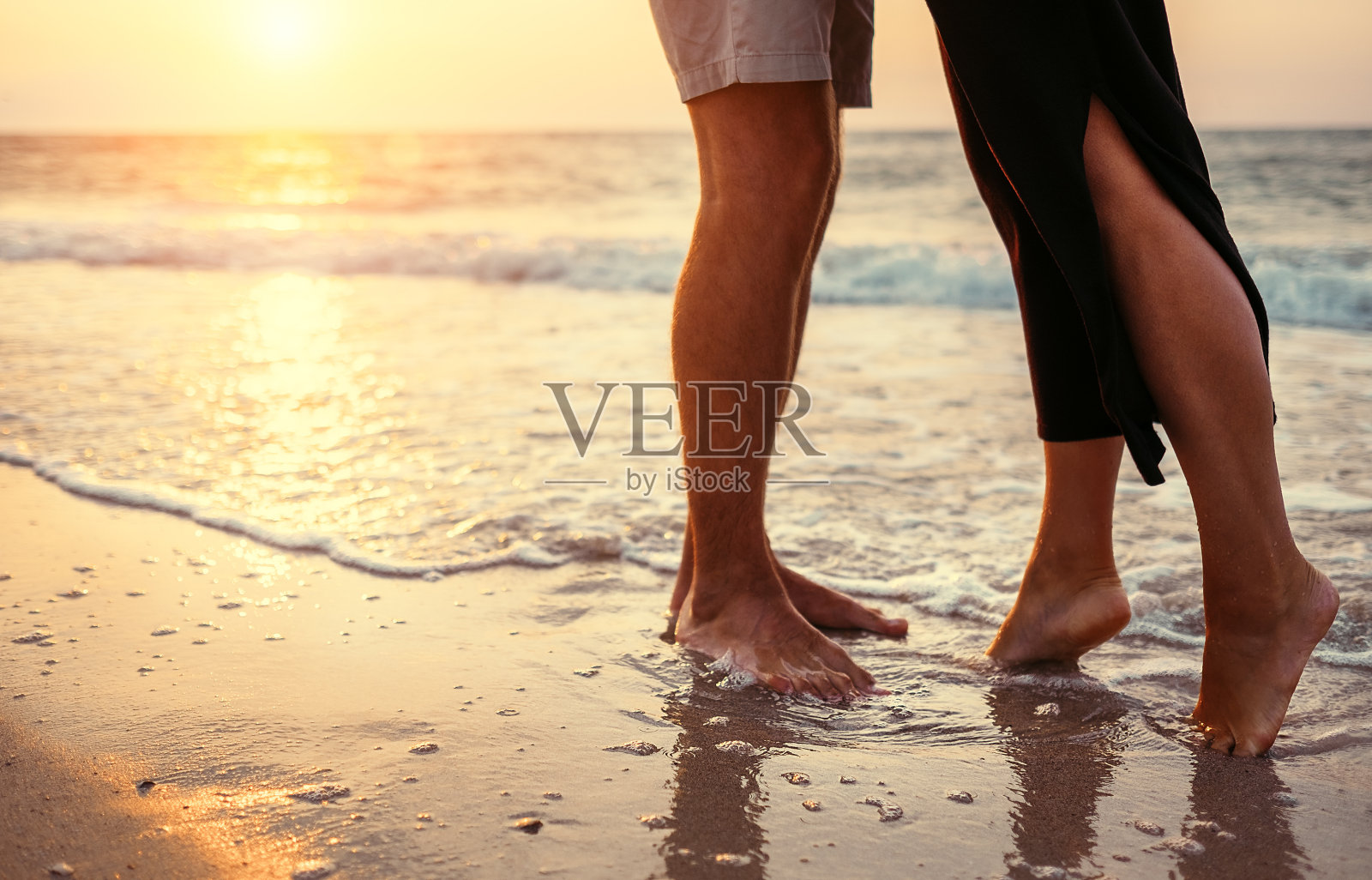 一对相爱的情侣在日出的海边照片摄影图片