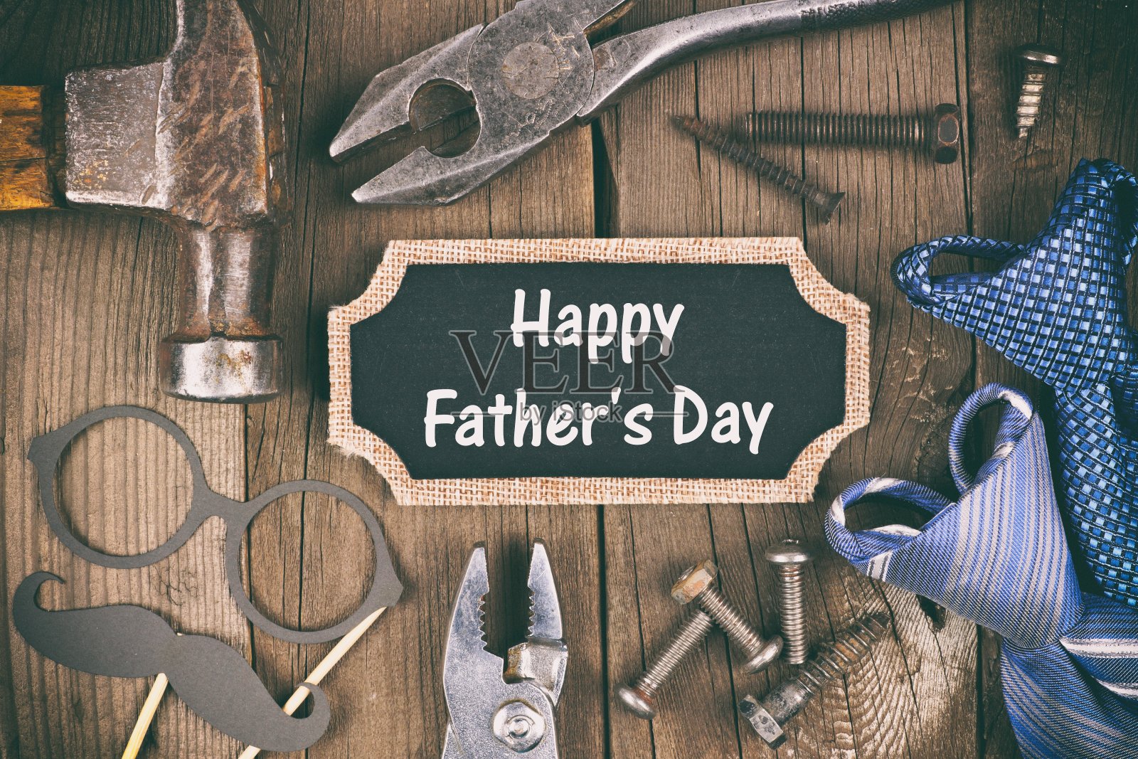 “父亲节快乐”的黑板标签，上面有工具、礼物和木制的领带框照片摄影图片