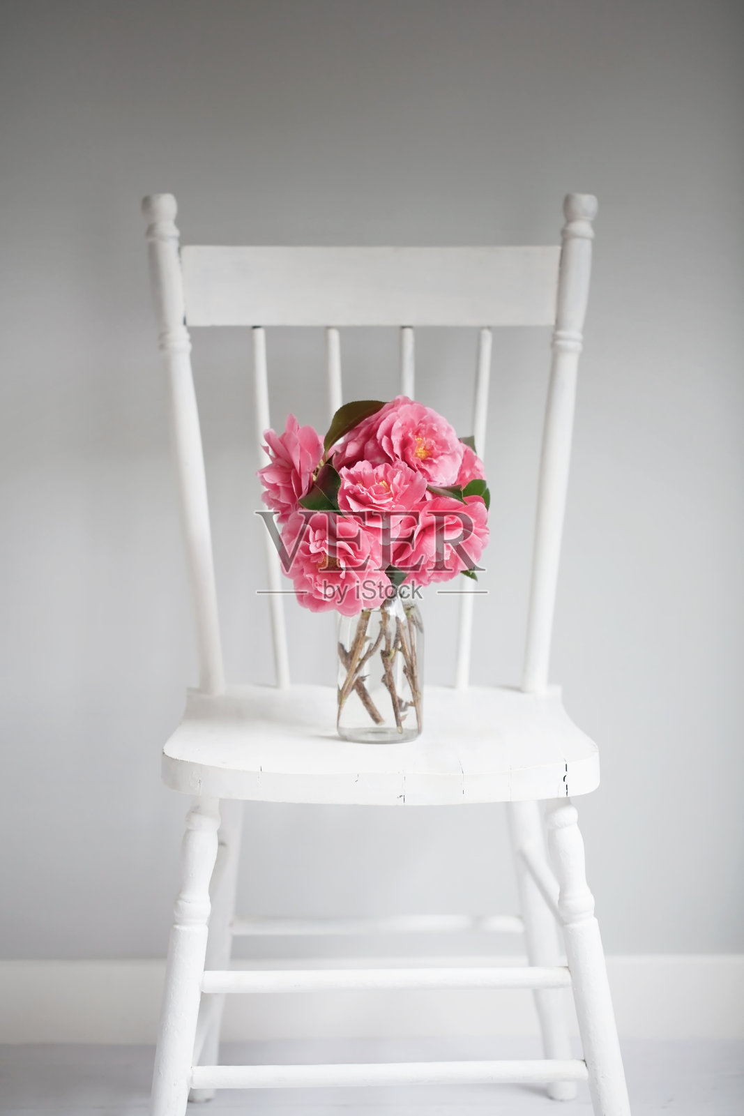 白色垂直椅子，粉红色的花照片摄影图片