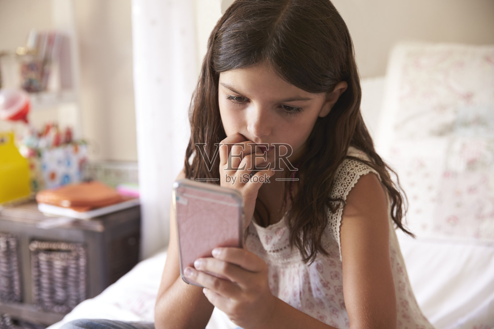 卧室里的年轻女孩担心被欺负的短信照片摄影图片