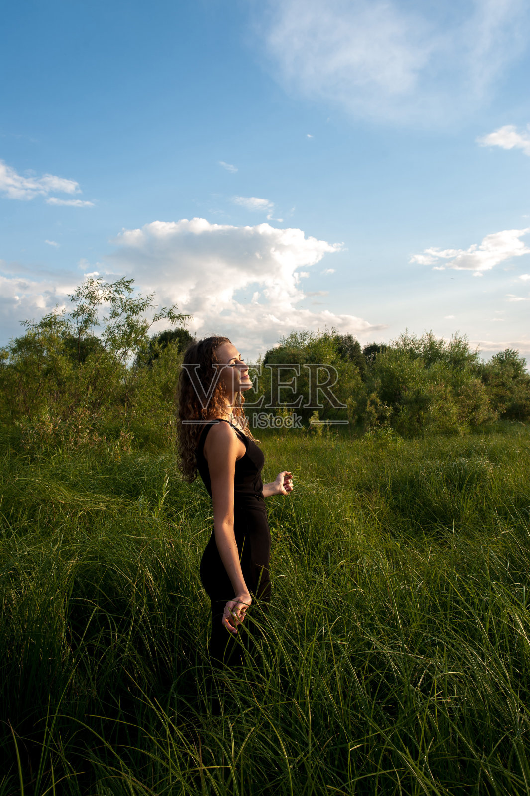 美丽的女孩走在高高的草丛中照片摄影图片
