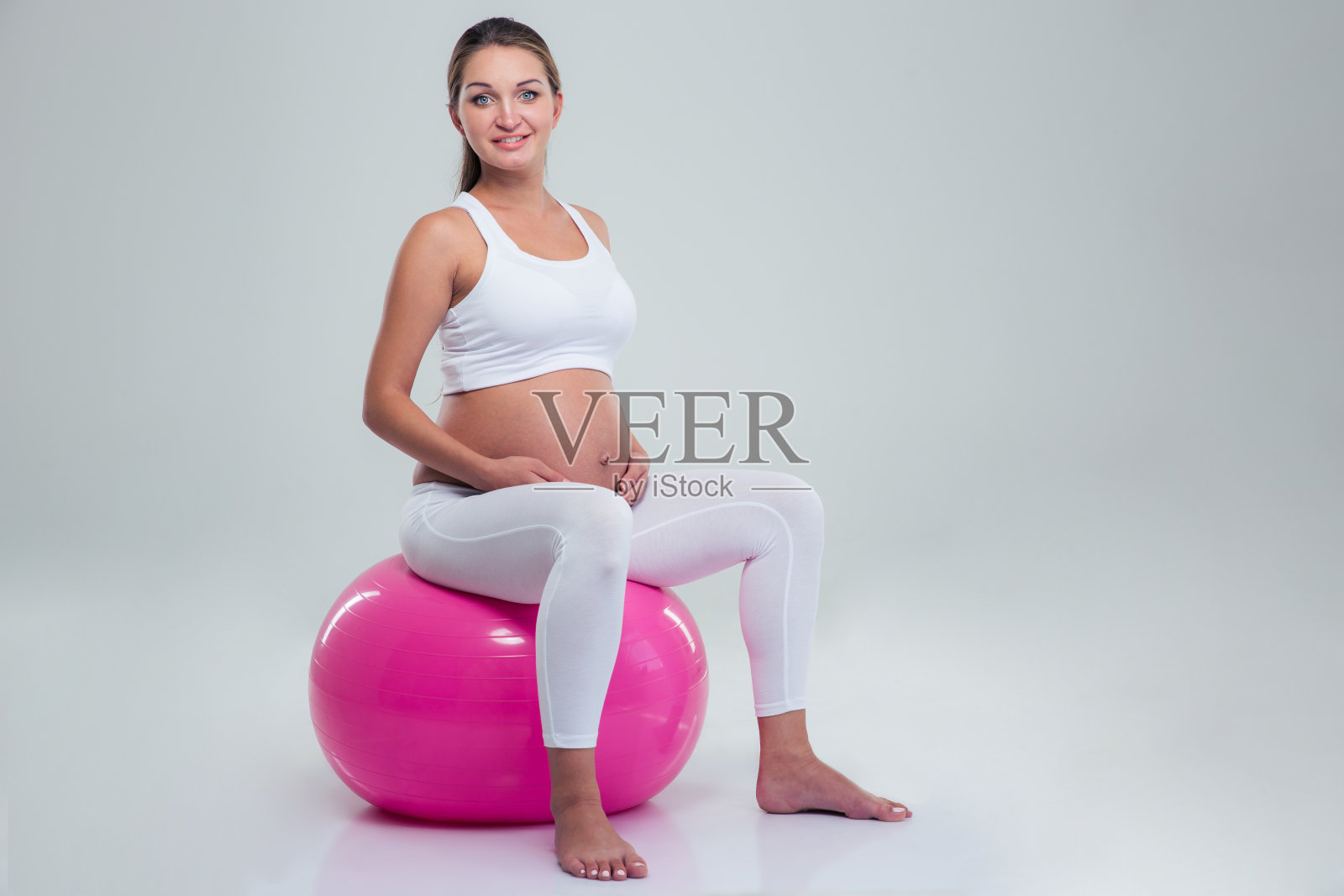 孕妇坐在健身球上照片摄影图片