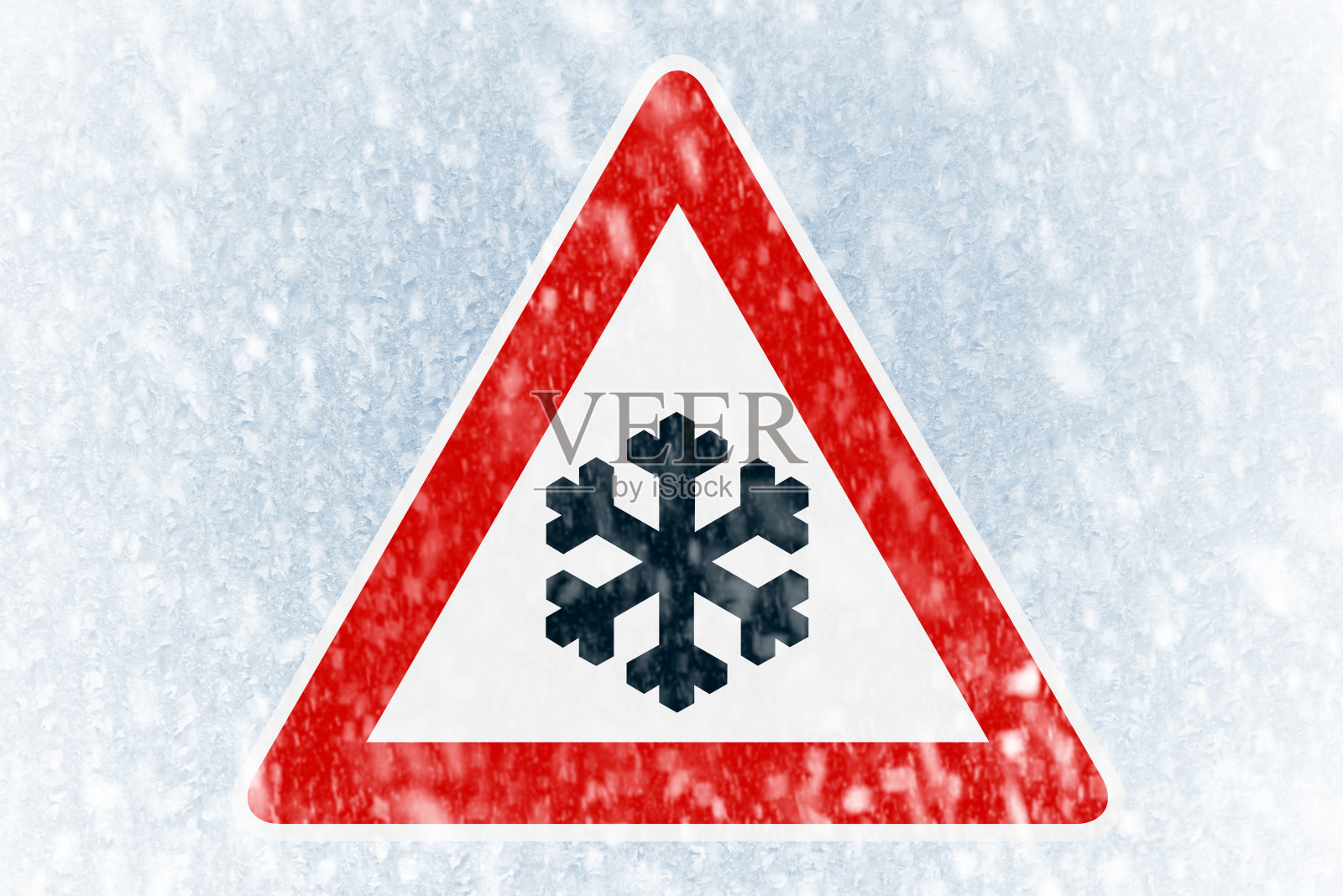 冬天开车——挡风玻璃上结满了冰，上面有警告标志照片摄影图片