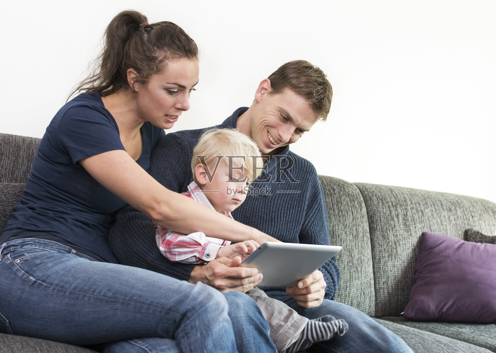 年轻夫妇和孩子在沙发上照片摄影图片