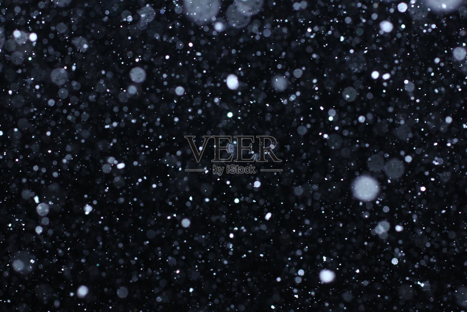 暴风雪纹理。散景灯和落雪在黑色的背景上背景图片素材