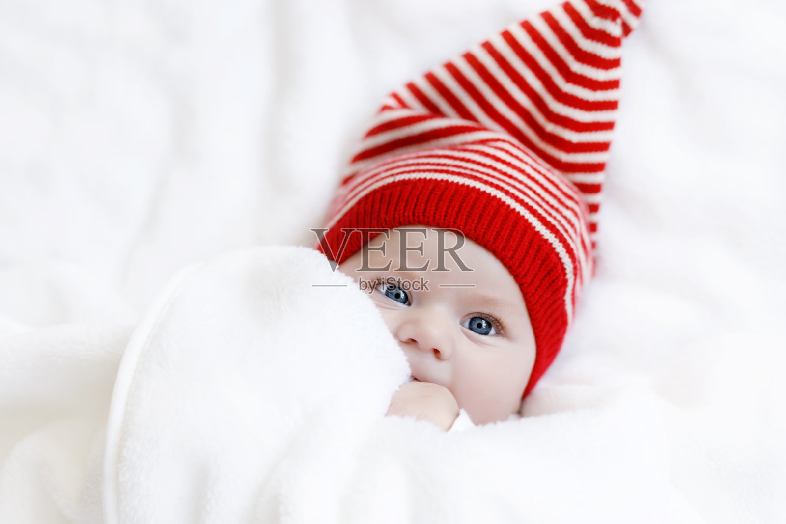 可爱可爱的婴儿与圣诞冬天的帽子在白色的背上照片摄影图片