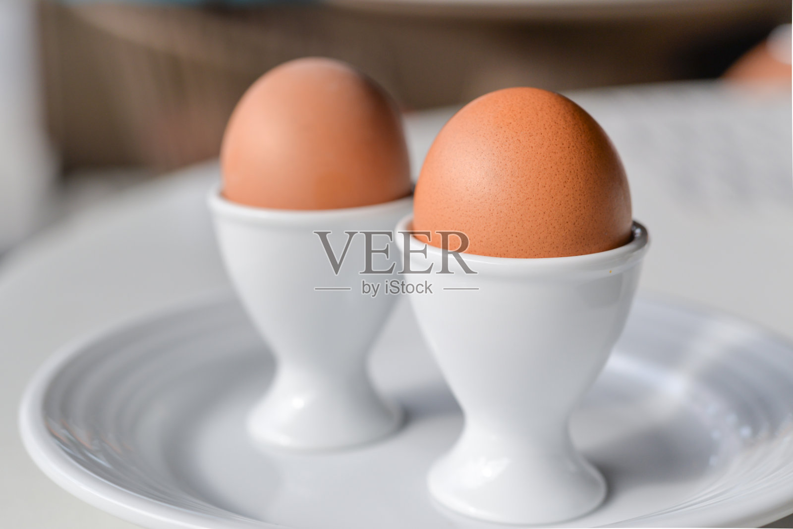在白色盘子上的鸡蛋杯煮鸡蛋照片摄影图片