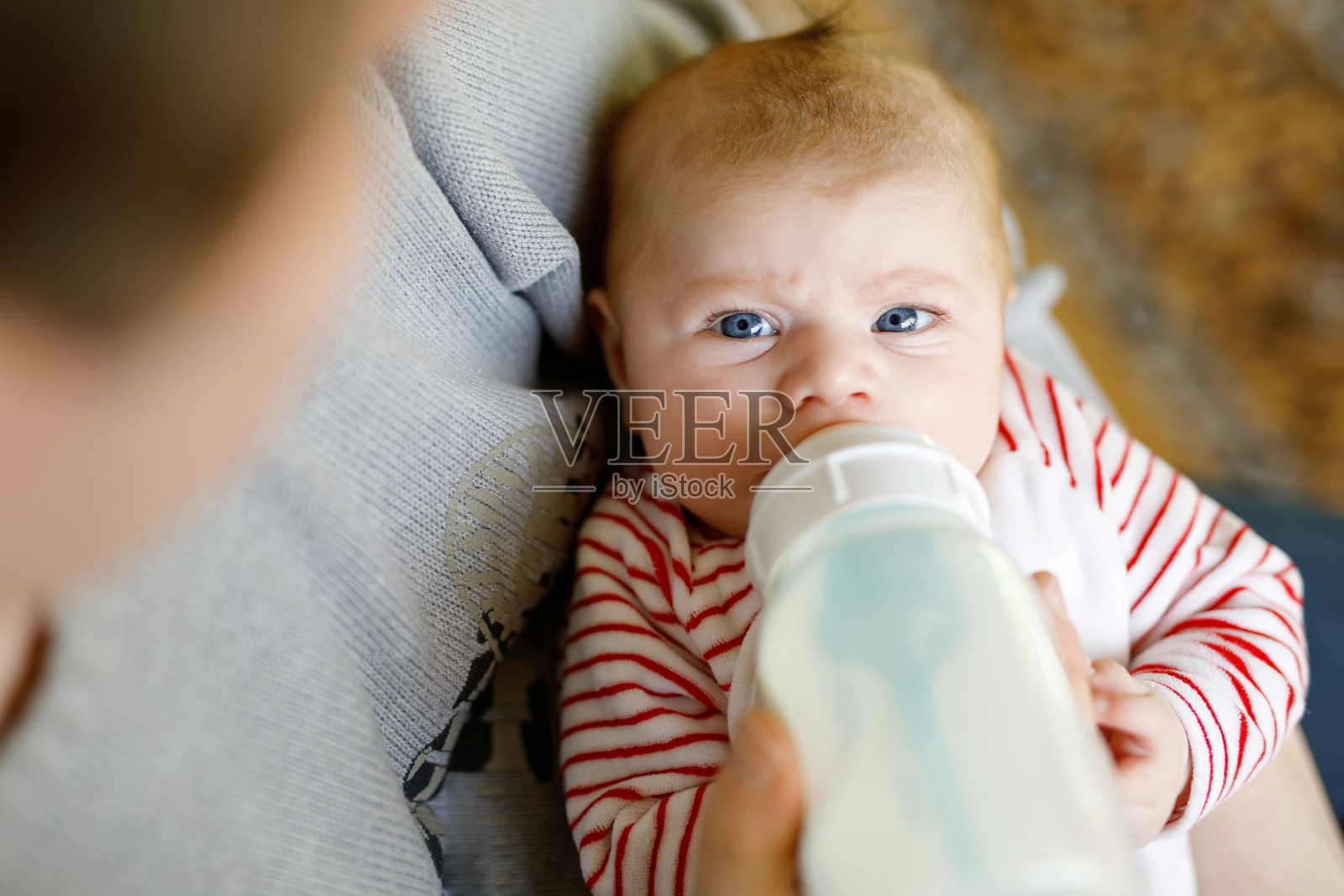 父亲用奶瓶喂刚出生的女儿照片摄影图片
