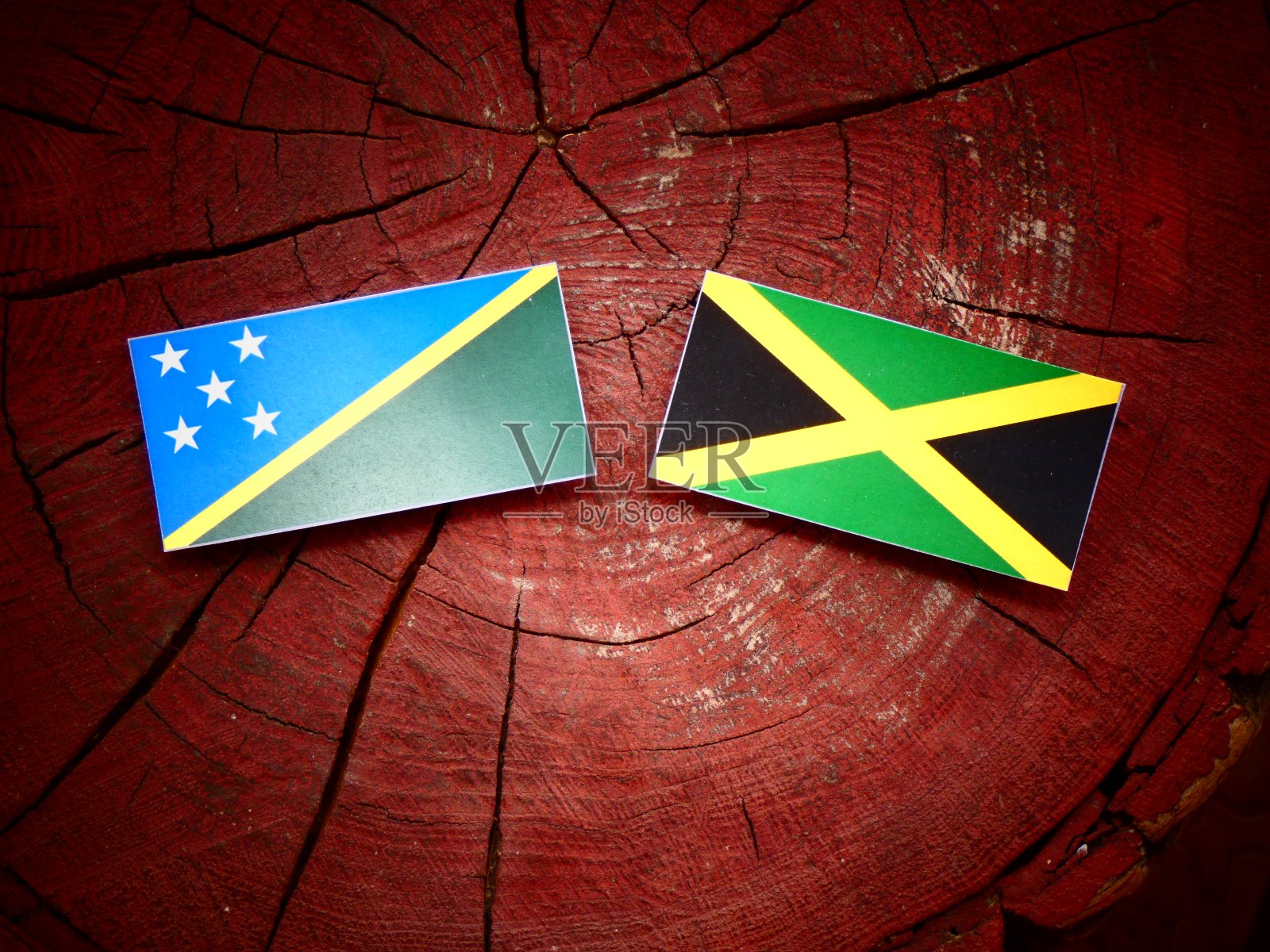 孤立的树桩上悬挂着所罗门群岛国旗和牙买加国旗照片摄影图片