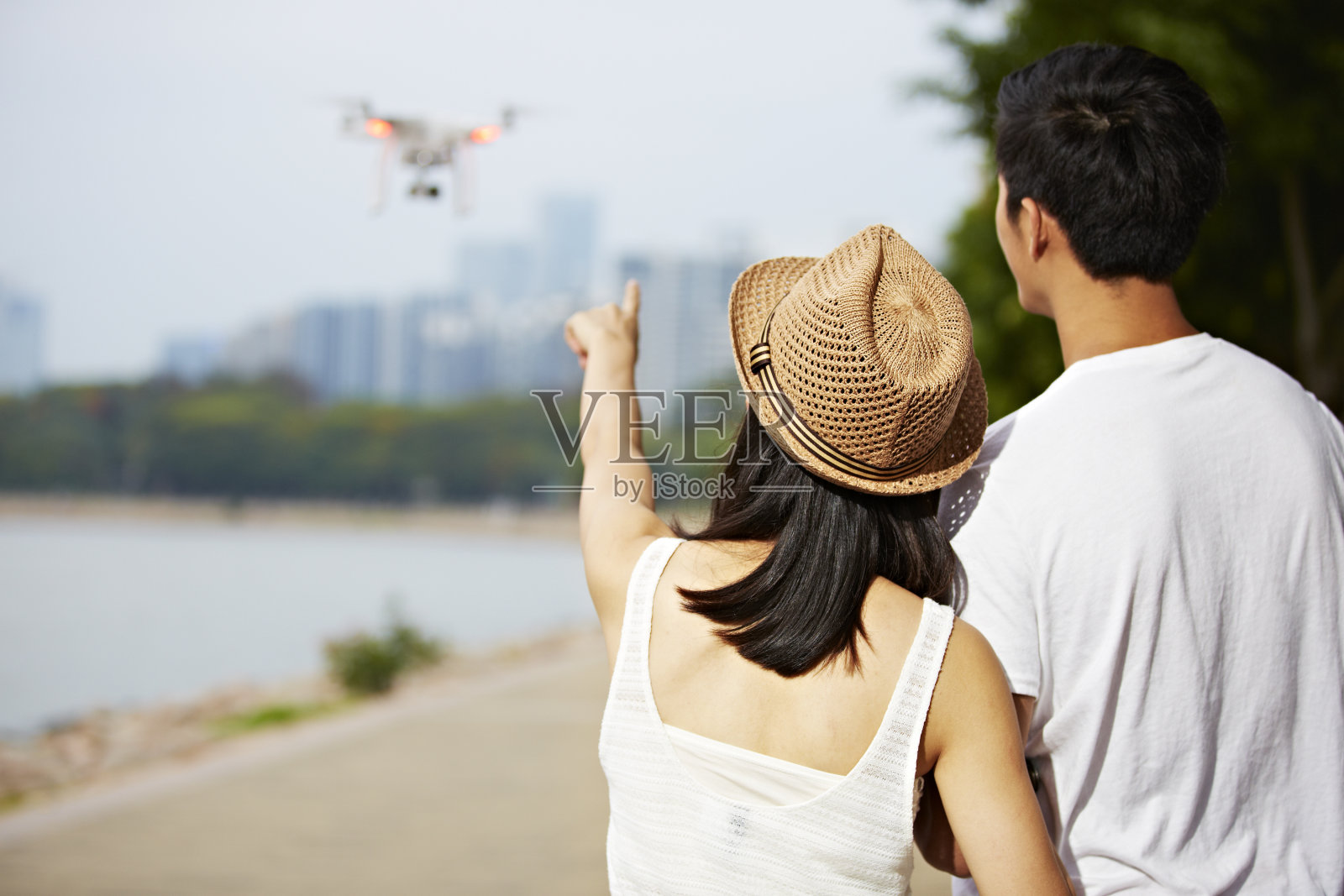 操控无人机的年轻夫妇照片摄影图片