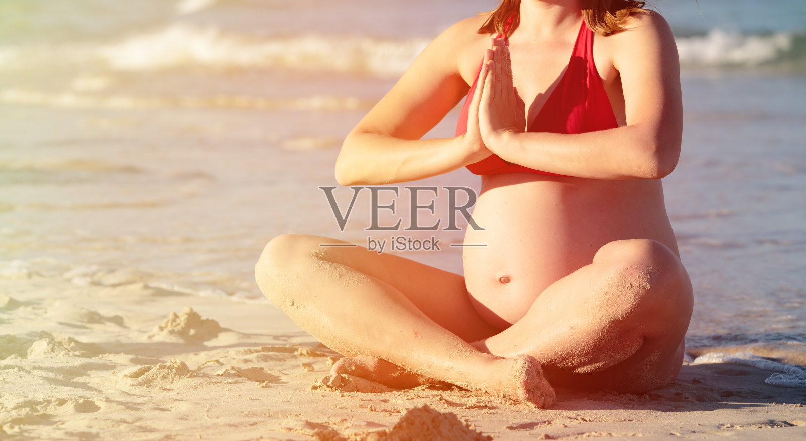 在海滩上练习瑜伽的孕妇照片摄影图片