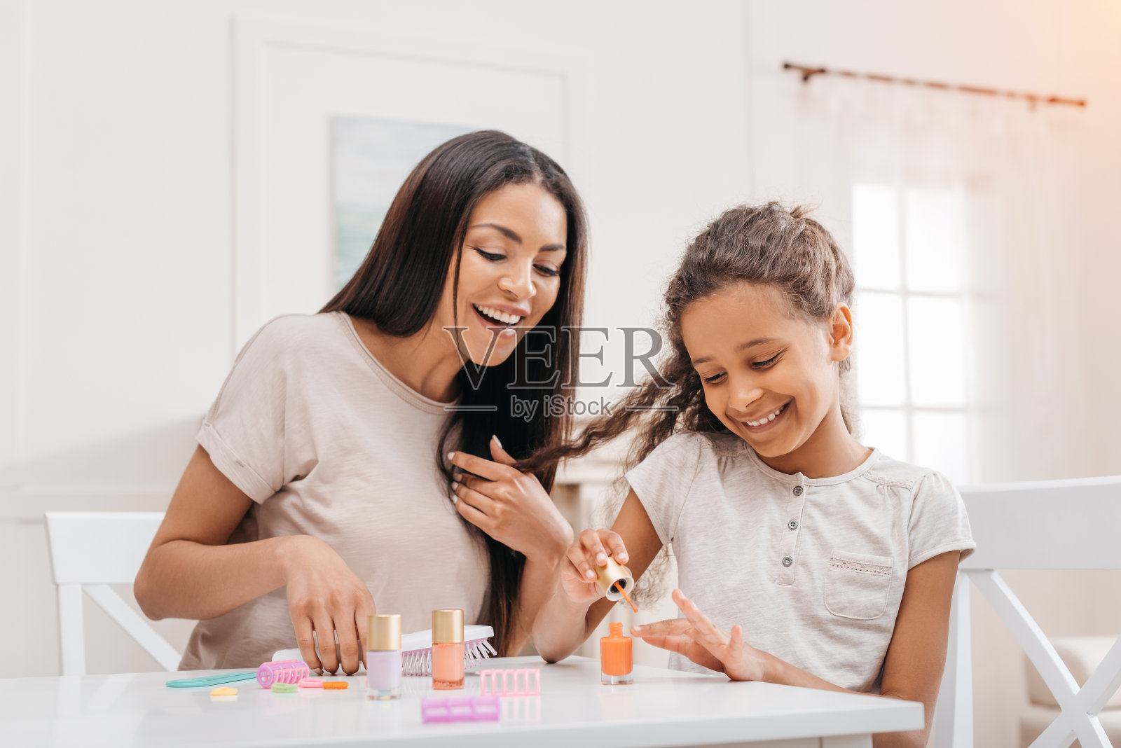 非裔美国母亲看着开心的女儿在家修指甲照片摄影图片