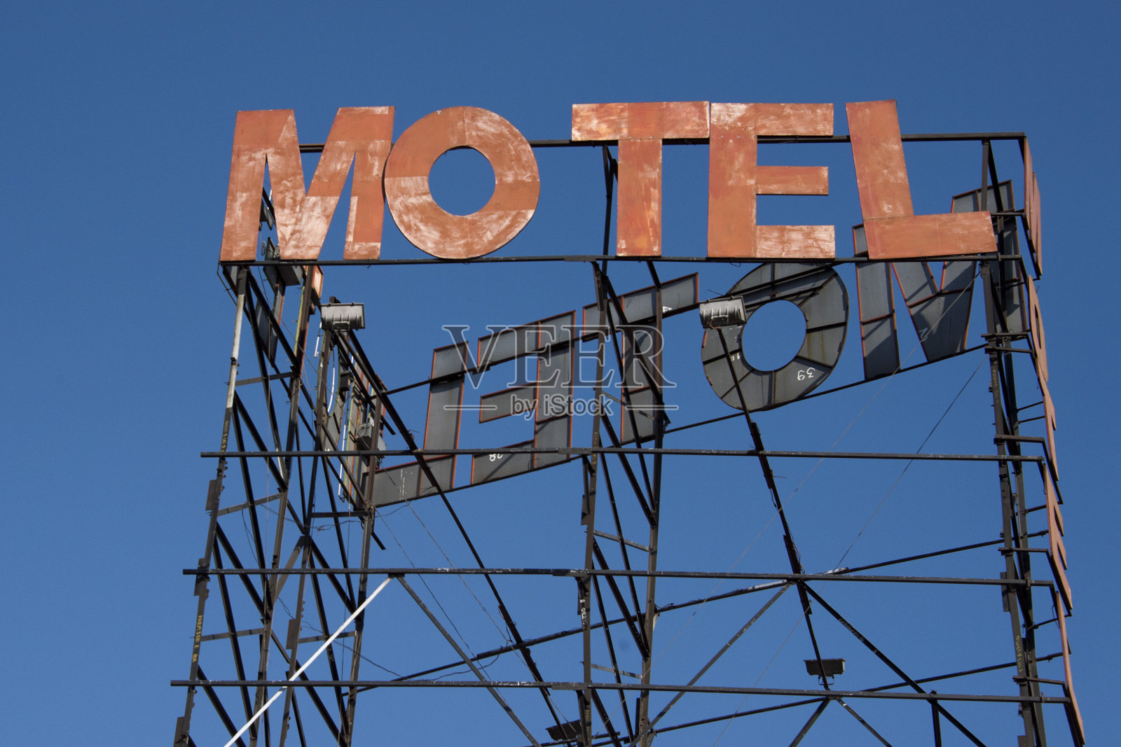汽车旅馆生锈的标志上的蓝天背景照片摄影图片
