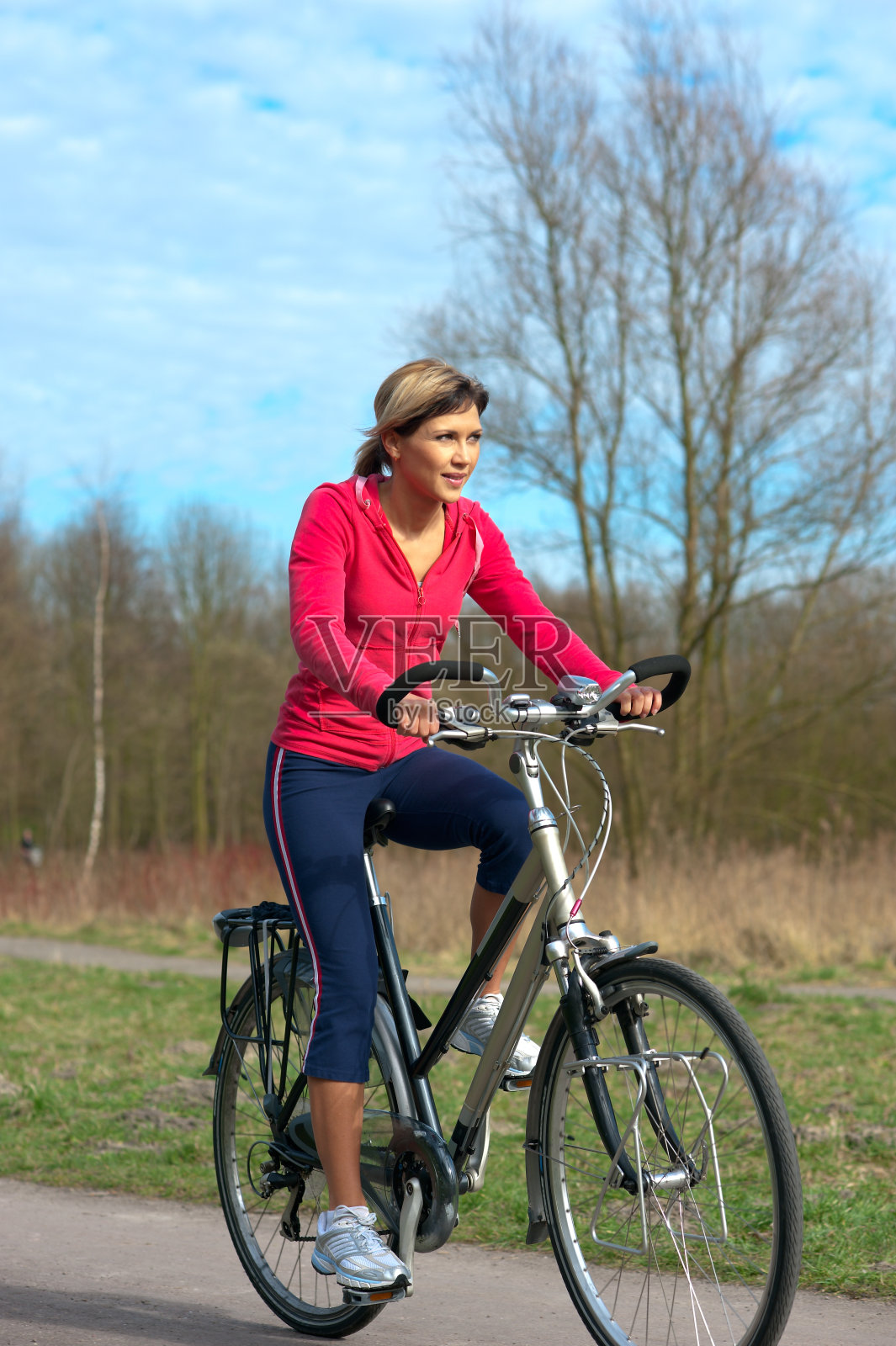 在公园里骑自行车的女人。照片摄影图片