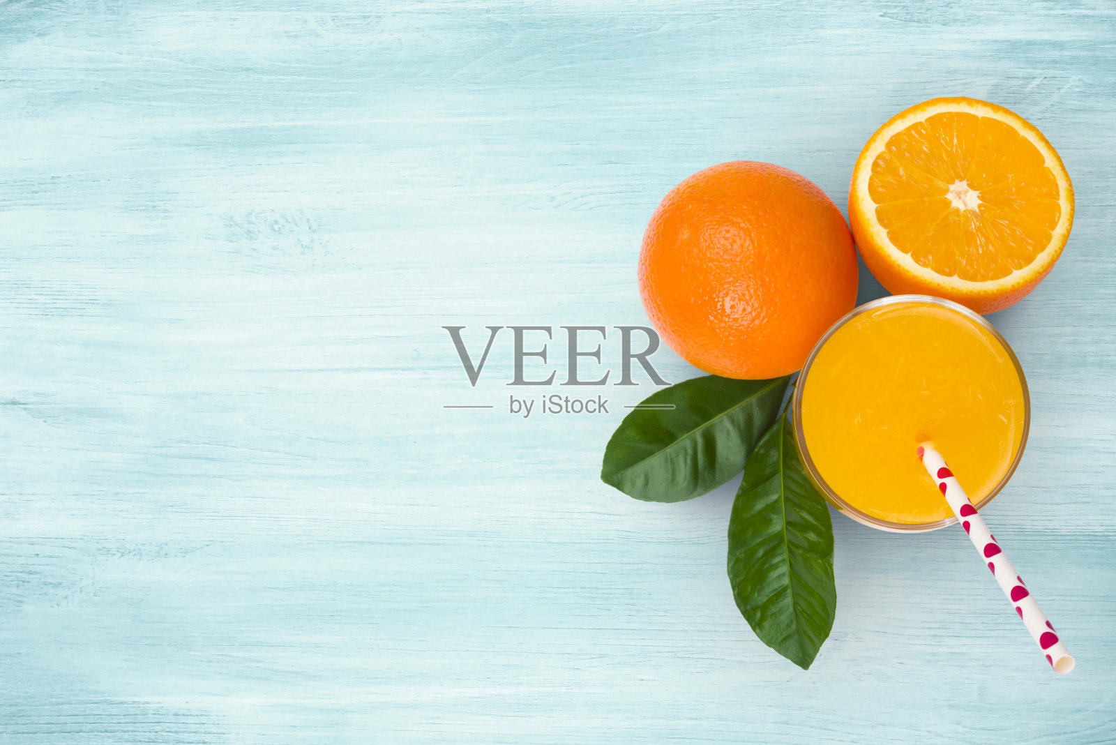 橙汁杯和水果在蓝色木制热带背景照片摄影图片