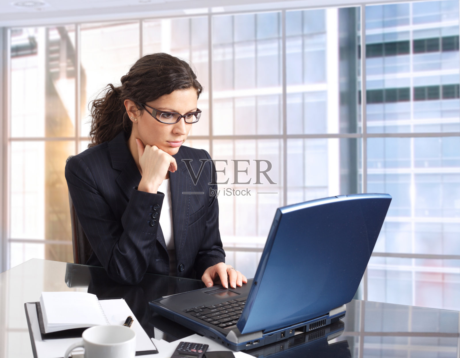 商务女性在大型建筑的办公室里使用笔记本电脑照片摄影图片