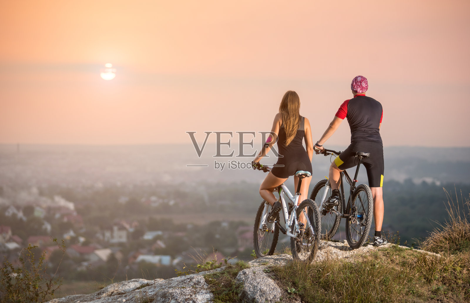 骑自行车的夫妇与山地车在山上日落照片摄影图片