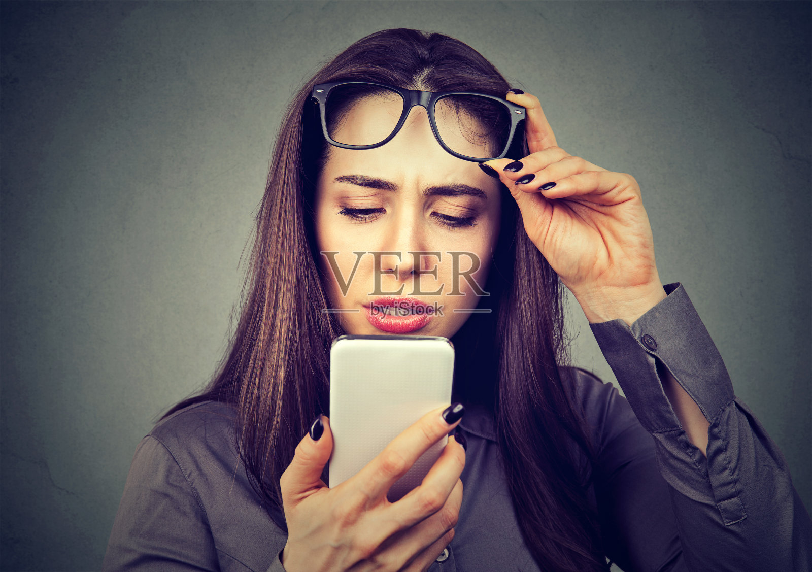 戴眼镜看不清手机的女性有视力问题照片摄影图片