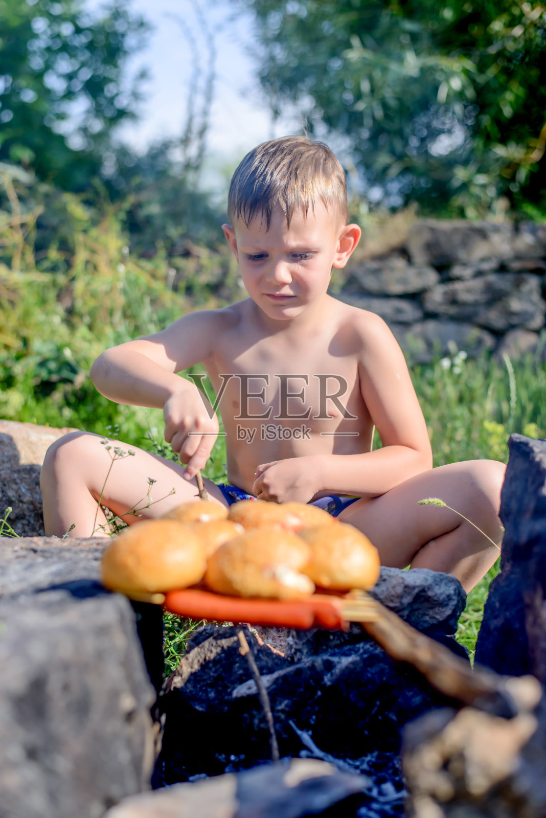 赤裸上身的男孩烤面包和香肠照片摄影图片