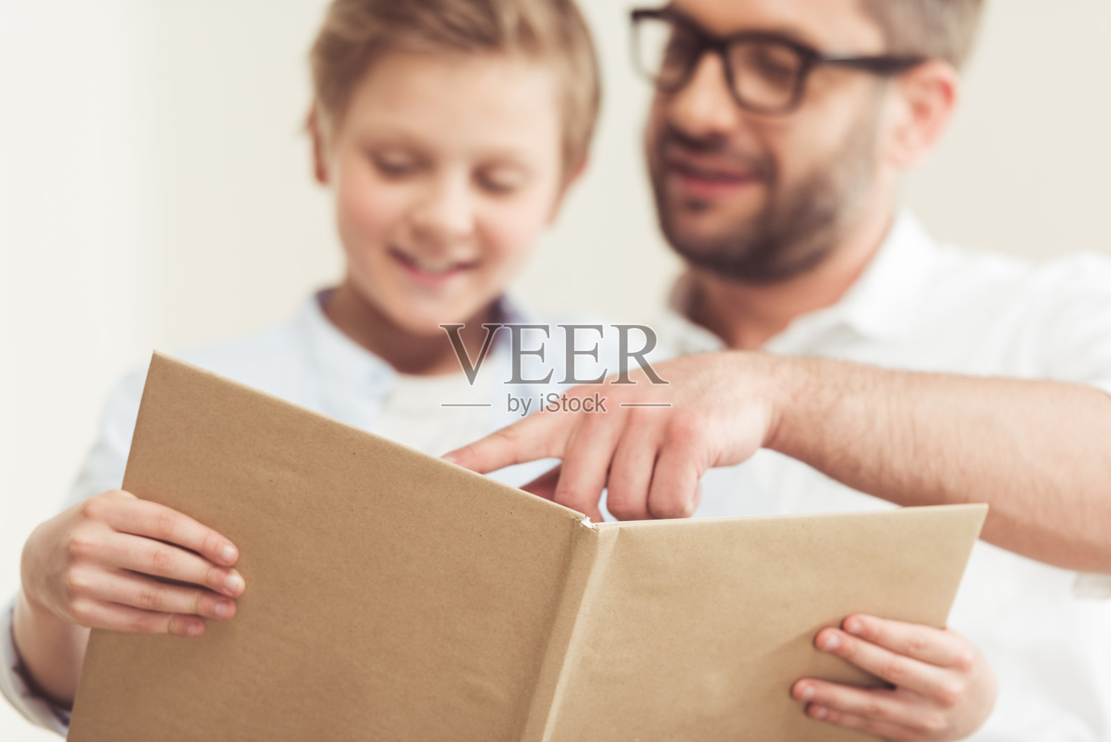 小儿子和爸爸一起在家看书照片摄影图片